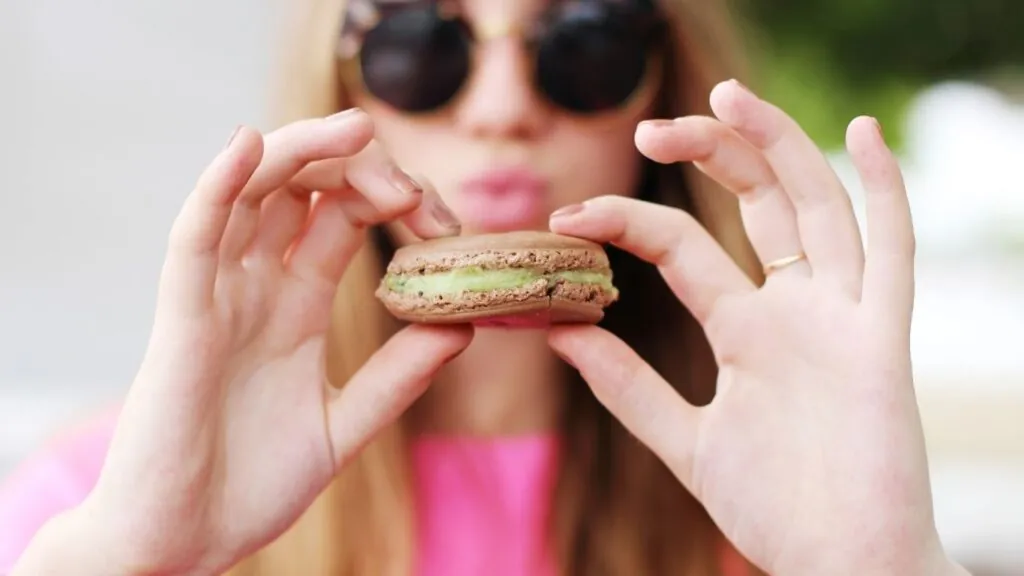Quantos doces por pessoa: mulher segurando um Macaron.