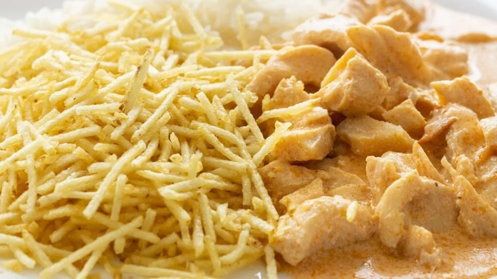 comidas fáceis para servir na sua festa: strogonoff de frango com arroz branco e batata palha.